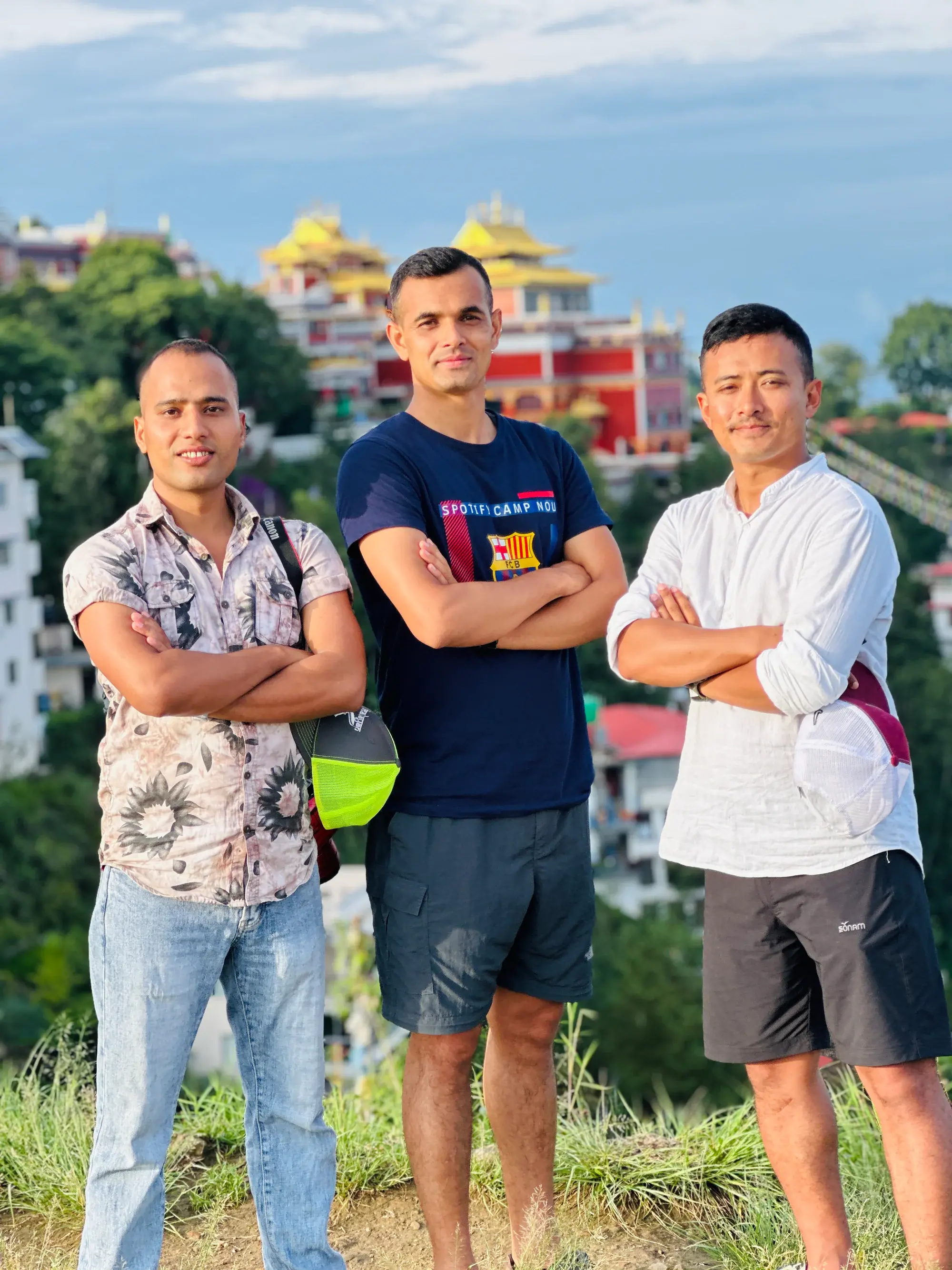 Three friends overlooking a Buddhist monastery and the green hills of Kathmandu Valley