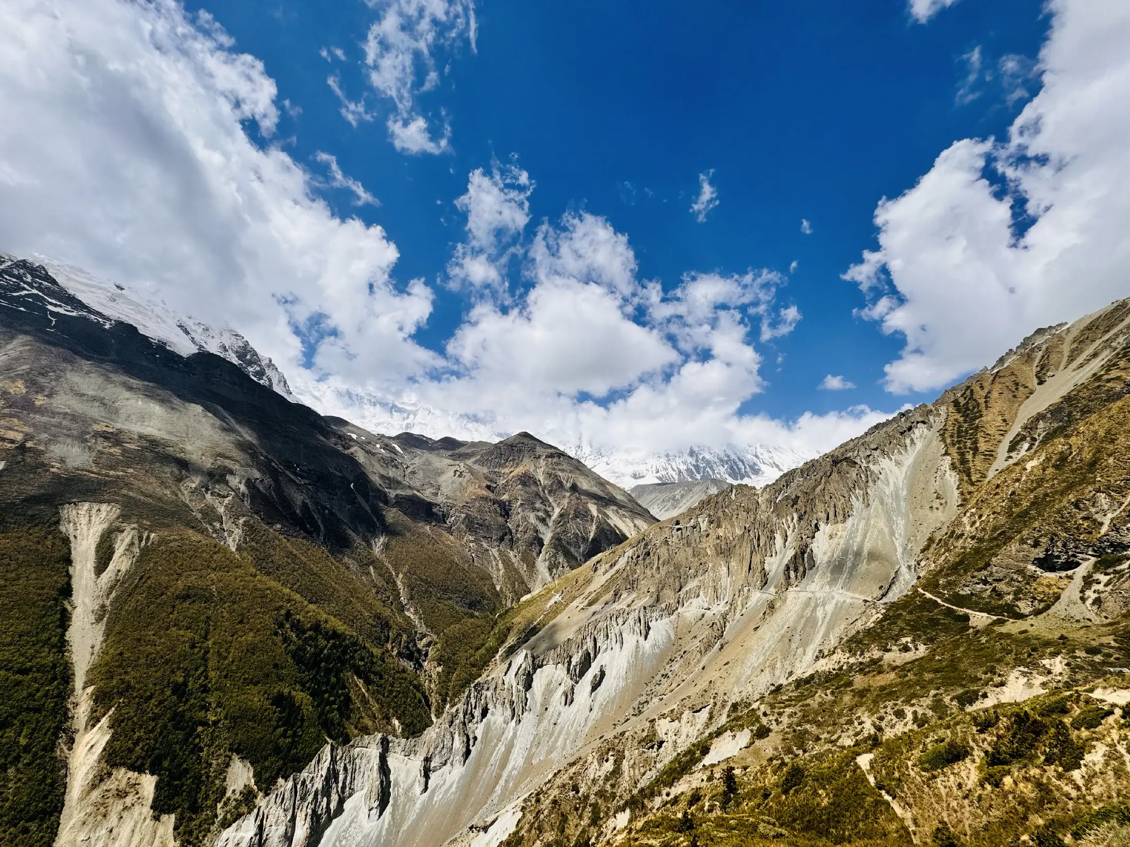 A high trail winding through the rocky Annapurna landscape beneath a deep blue sky